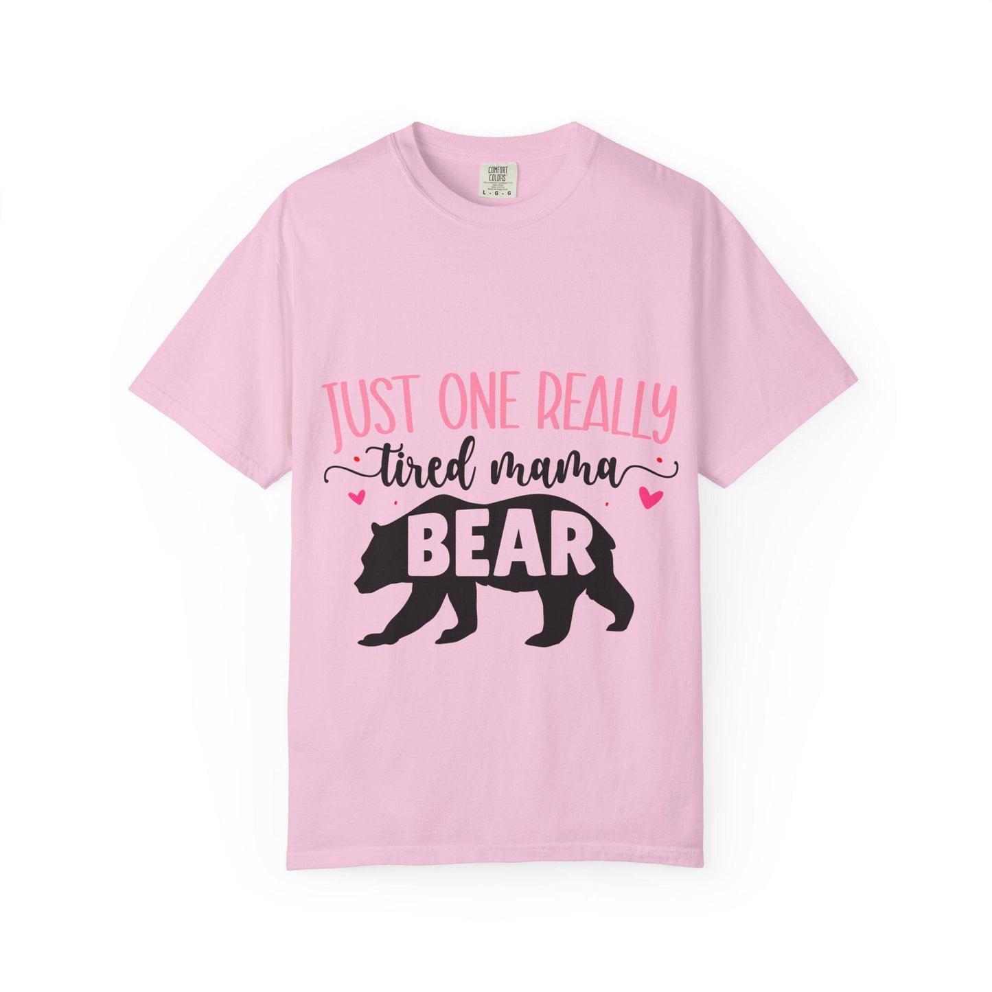 Light pink Comfort Colors short sleeve t-shirt featuring the phrase “Just One Really Tired Mama Bear” in playful pink and black fonts. The design includes a bold black silhouette of a walking bear with the word “BEAR” in pink block letters inside the bear, and small pink hearts for added charm. A cozy, fun, and relatable shirt for moms, perfect for Mother’s Day, new moms, or as a comfy everyday mom life tee.